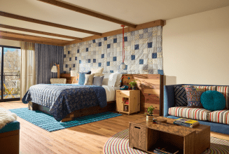 Hotel suite with king bed and living area furnished with couch and coffee table