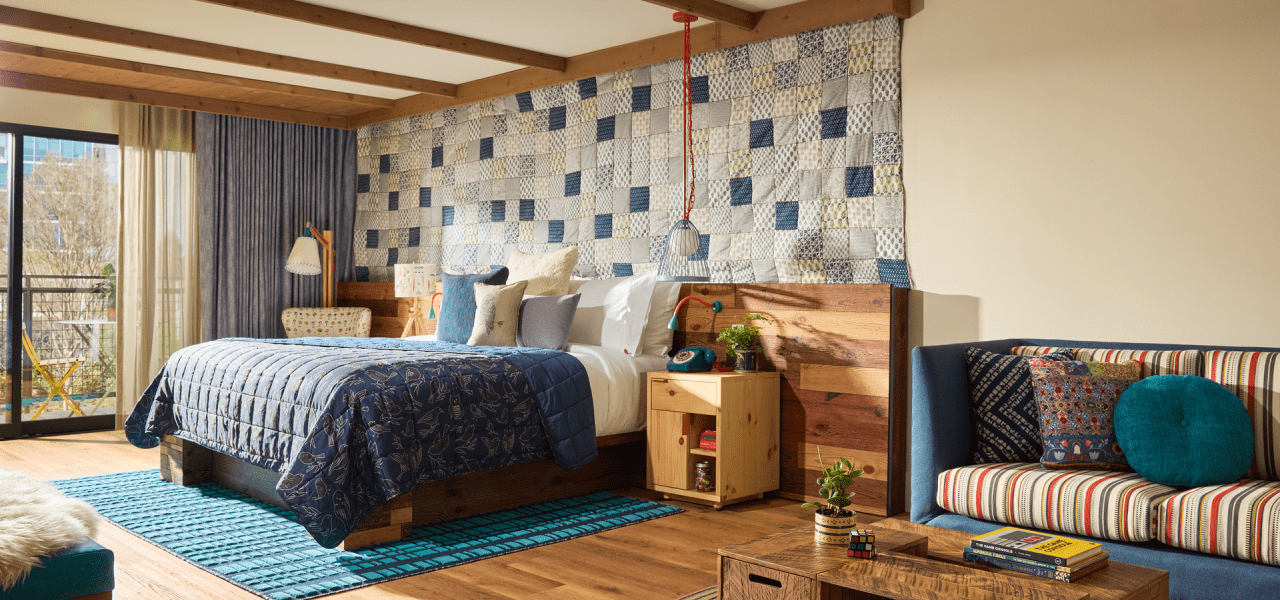 Hotel suite with king bed and living area furnished with couch and coffee table